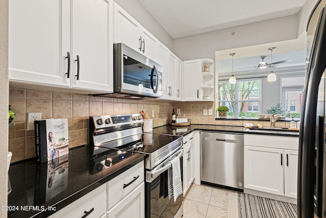 kitchen with white cabinets, light tile floors, ceiling fan, and appliances with stainless steel finishes