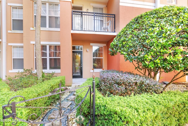 view of exterior entry featuring a balcony