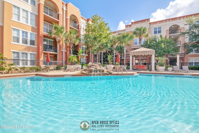 view of pool with a gazebo and pool water feature