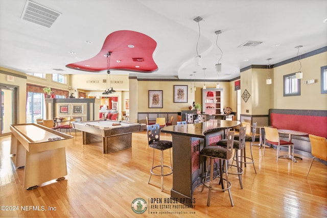 kitchen featuring a kitchen island, decorative light fixtures, a kitchen breakfast bar, and light wood-type flooring