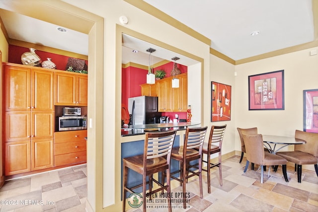 kitchen featuring hanging light fixtures, stainless steel appliances, and light tile floors