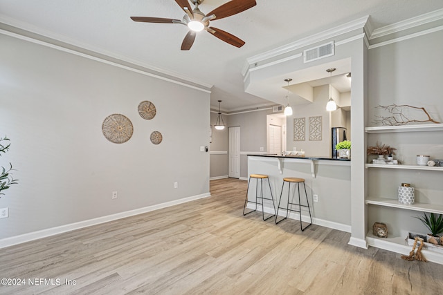 kitchen featuring pendant lighting, a breakfast bar area, ceiling fan, and light wood-type flooring