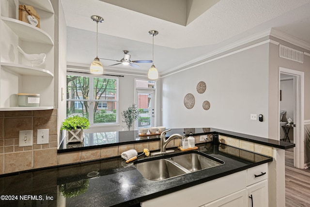 kitchen with hardwood / wood-style floors, decorative light fixtures, white cabinetry, ceiling fan, and sink