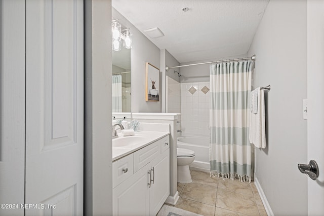 full bathroom featuring tile floors, a textured ceiling, shower / tub combo, toilet, and vanity with extensive cabinet space