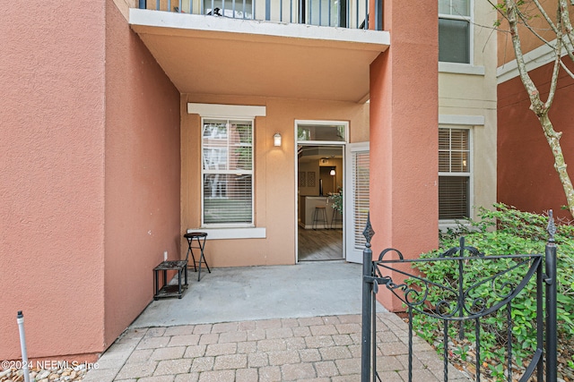 property entrance with a balcony and a patio