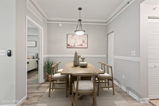 dining space featuring light hardwood / wood-style floors and ornamental molding