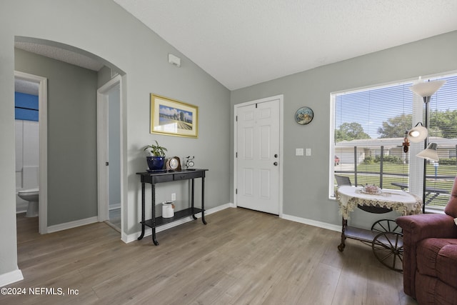 foyer featuring vaulted ceiling and light hardwood / wood-style flooring