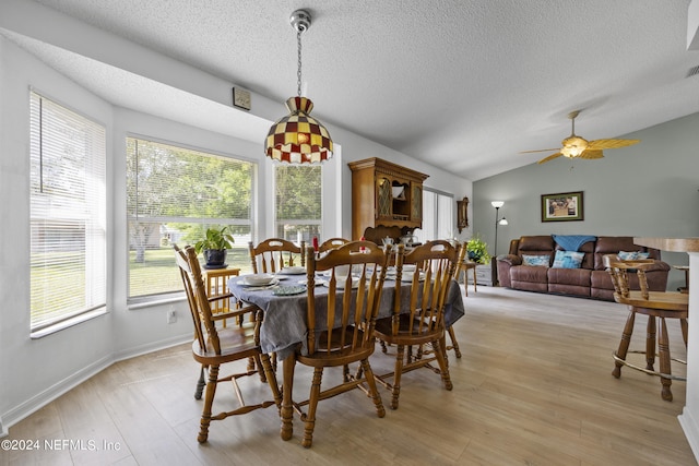 dining room with lofted ceiling, a textured ceiling, ceiling fan, and light hardwood / wood-style flooring