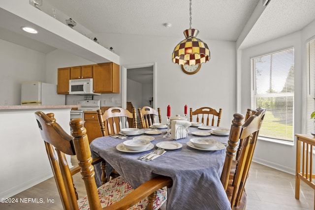 dining space with lofted ceiling and a textured ceiling