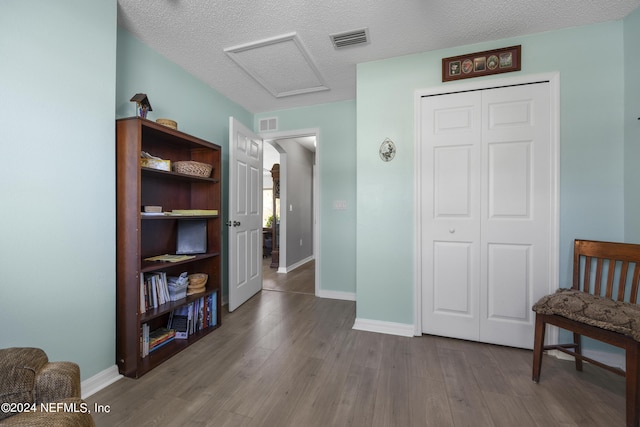 sitting room featuring a textured ceiling and dark hardwood / wood-style floors