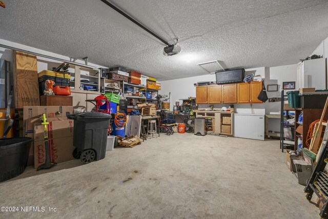 garage with a garage door opener and white fridge