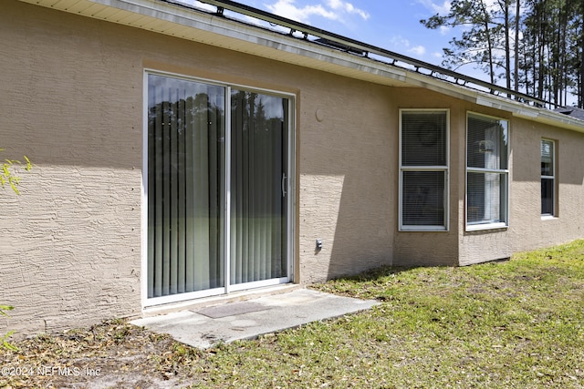 entrance to property with a lawn