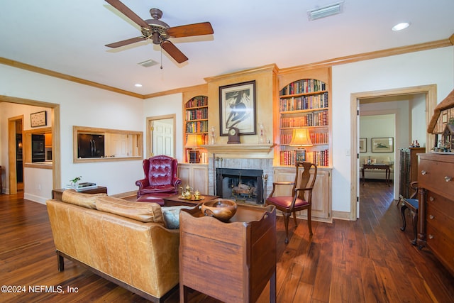 living room featuring ornamental molding, dark hardwood / wood-style flooring, ceiling fan, and built in shelves