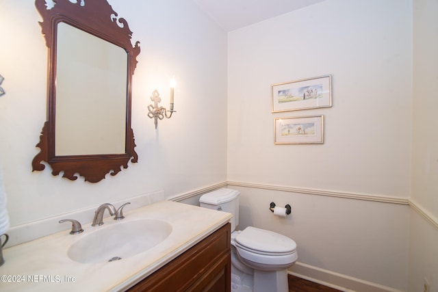 bathroom with hardwood / wood-style flooring, vanity, and toilet