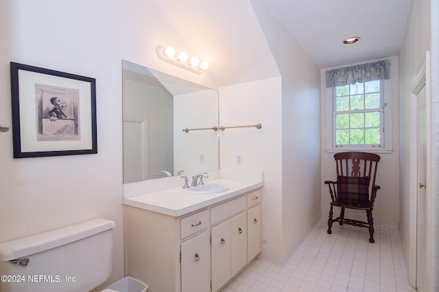 bathroom with tile floors, vanity with extensive cabinet space, and toilet