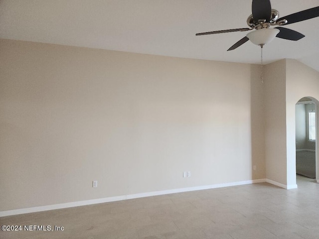 spare room with baseboards, arched walkways, and a ceiling fan