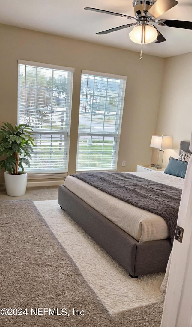 bedroom with multiple windows and a ceiling fan