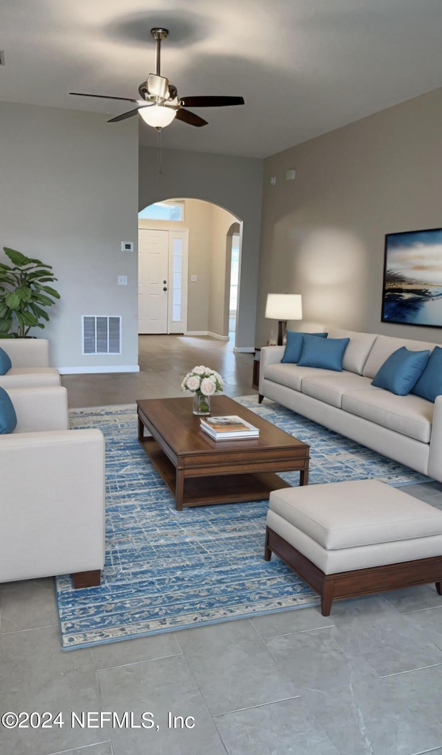 living room featuring arched walkways, visible vents, and a ceiling fan