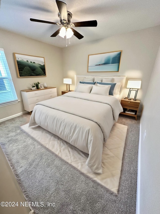 carpeted bedroom featuring ceiling fan and baseboards