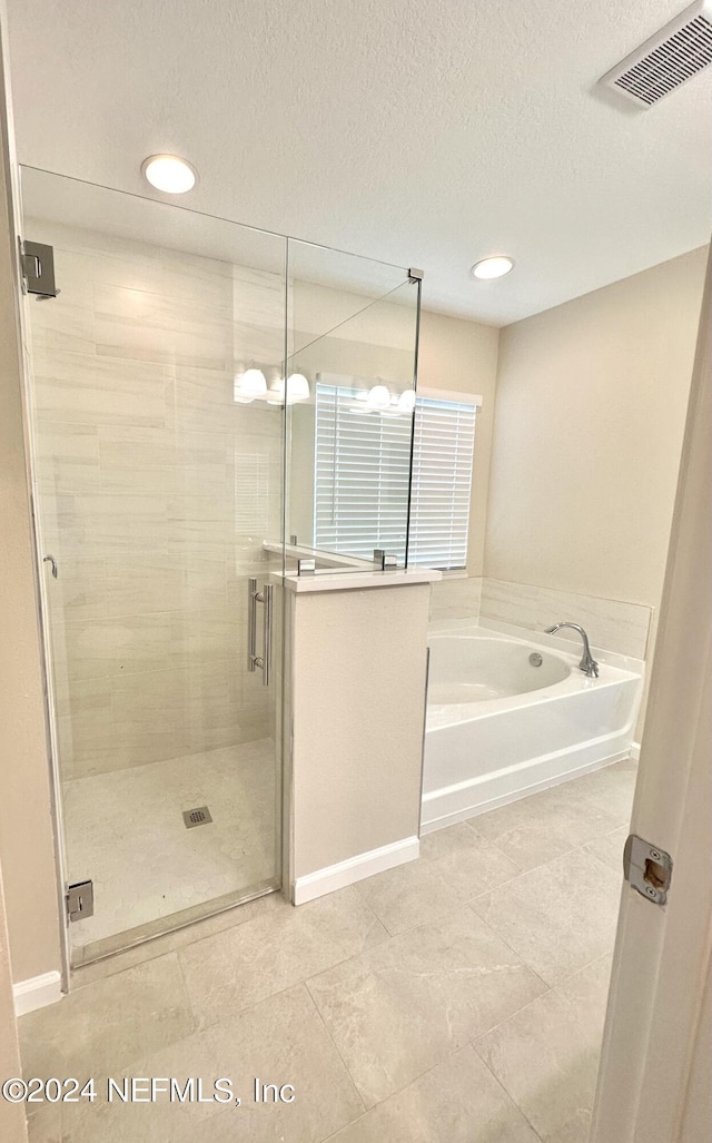 bathroom featuring recessed lighting, visible vents, a stall shower, a textured ceiling, and a bath