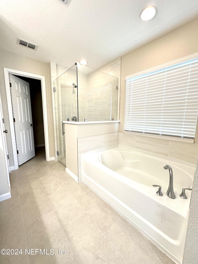 full bathroom with a stall shower, baseboards, visible vents, a textured ceiling, and a bath