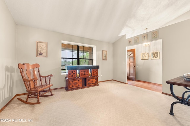 sitting room with vaulted ceiling and carpet flooring