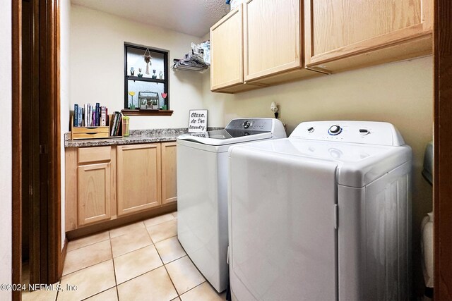 washroom featuring independent washer and dryer, cabinets, and light tile floors