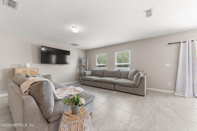 living room with light tile floors and a textured ceiling