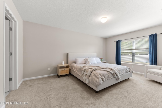 carpeted bedroom featuring a textured ceiling