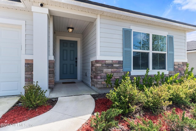 view of exterior entry with a garage