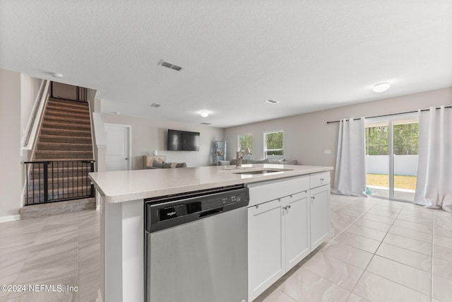 kitchen with stainless steel dishwasher, a wealth of natural light, a center island with sink, white cabinetry, and sink