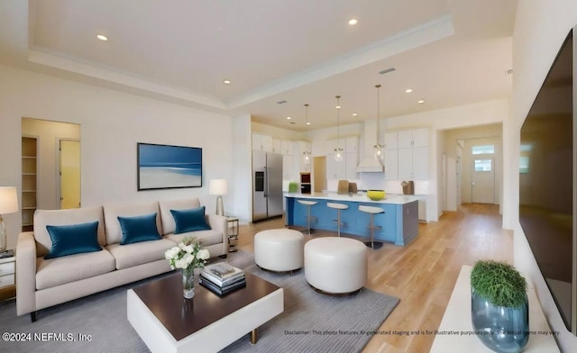 living room featuring a tray ceiling and light hardwood / wood-style flooring