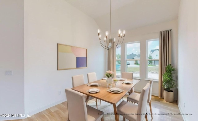 dining space with a notable chandelier, light hardwood / wood-style flooring, and vaulted ceiling