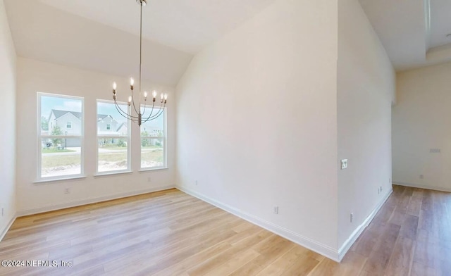 unfurnished dining area with vaulted ceiling, an inviting chandelier, and light hardwood / wood-style floors