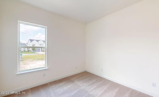 unfurnished room featuring carpet and plenty of natural light