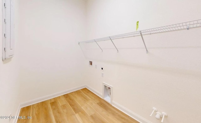 clothes washing area featuring wood-type flooring, hookup for a gas dryer, hookup for an electric dryer, and hookup for a washing machine