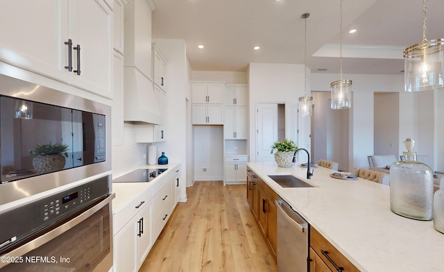 kitchen with dishwasher, sink, built in microwave, decorative light fixtures, and white cabinetry