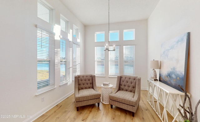 sitting room featuring hardwood / wood-style floors, a wealth of natural light, and a chandelier