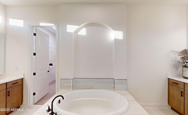 bathroom with vanity and tiled tub