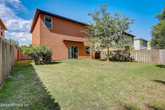 back of house with a lawn