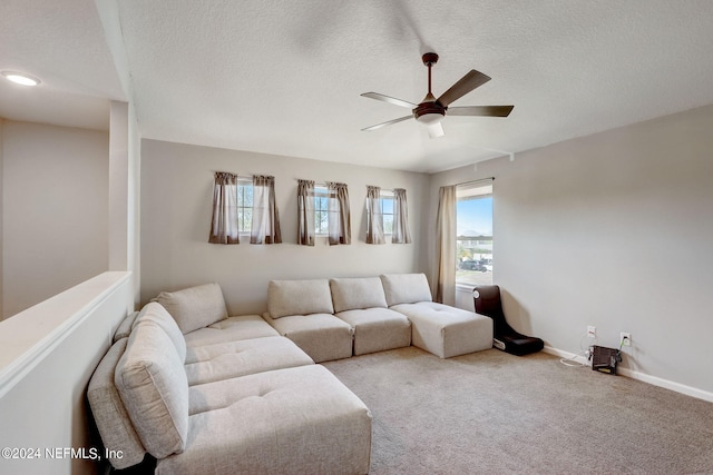 carpeted living room featuring a healthy amount of sunlight, ceiling fan, and a textured ceiling