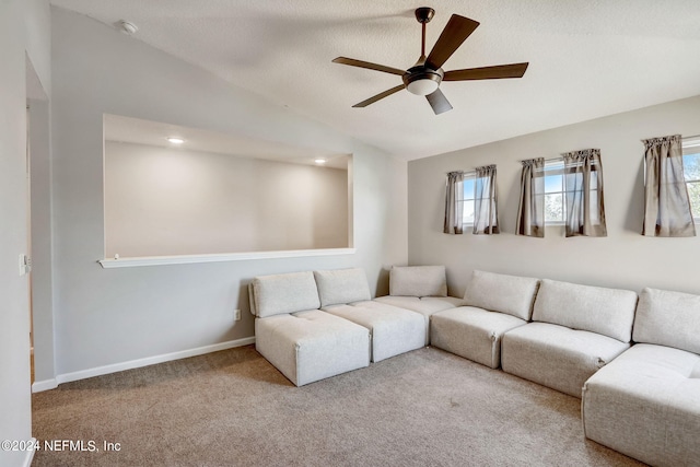 carpeted living room with lofted ceiling, ceiling fan, a wealth of natural light, and a textured ceiling