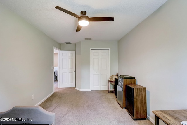 misc room with light colored carpet and ceiling fan