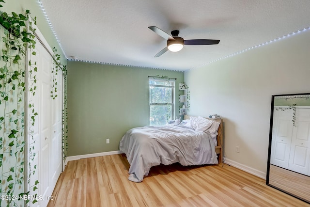 bedroom with light hardwood / wood-style flooring, ceiling fan, a textured ceiling, and a closet