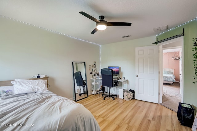 bedroom with light hardwood / wood-style floors and ceiling fan