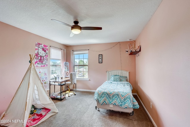 carpeted bedroom featuring ceiling fan and a textured ceiling