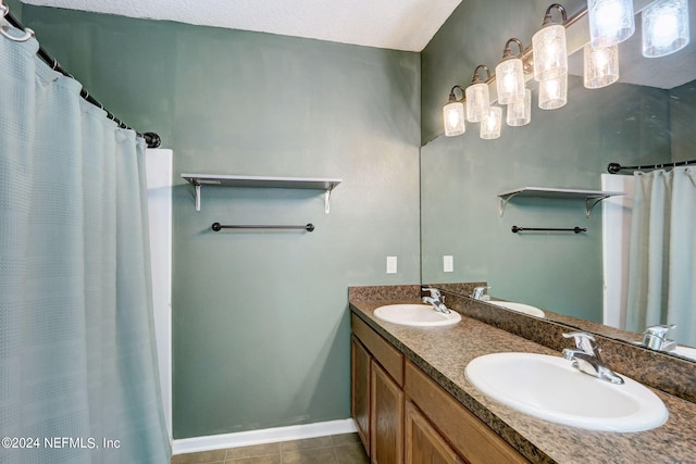 bathroom with vanity with extensive cabinet space, double sink, and tile flooring