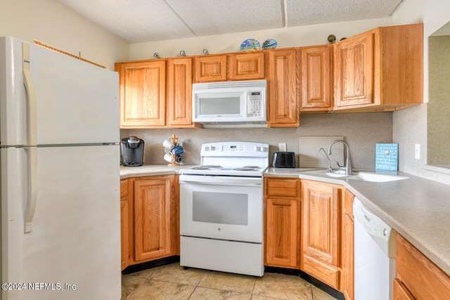 kitchen with white appliances, sink, and light tile floors