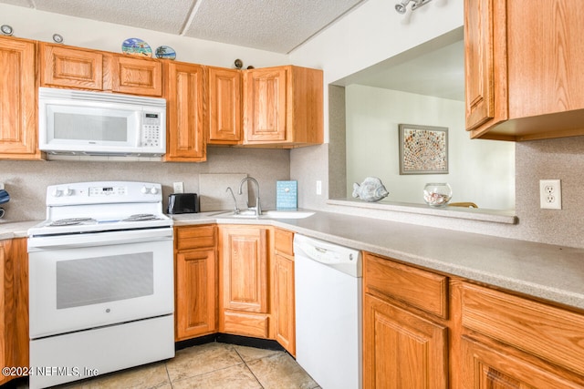 kitchen featuring light tile floors, white appliances, a textured ceiling, and sink