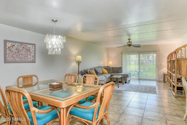 dining area with light tile floors, a textured ceiling, and ceiling fan with notable chandelier